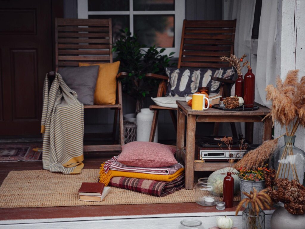 Autumn wooden patio, family heirlooms, with pumpkins and cozy blankets.