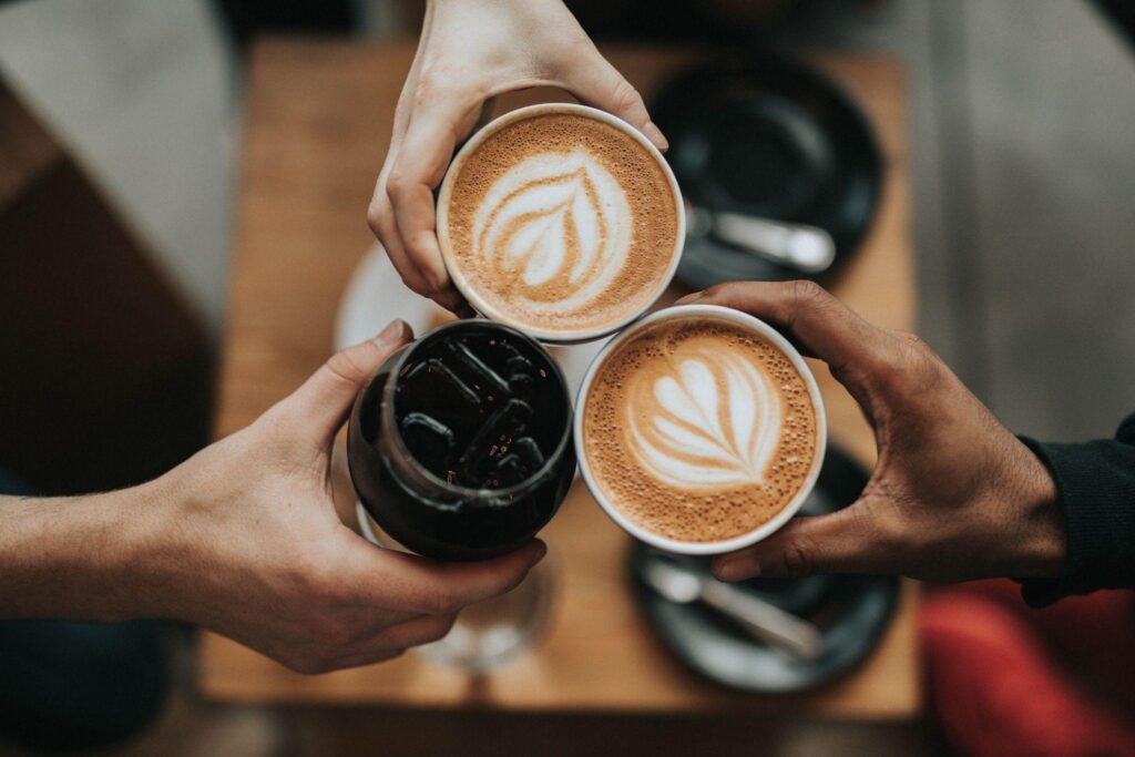 Three Person Holding holding cups of coffee